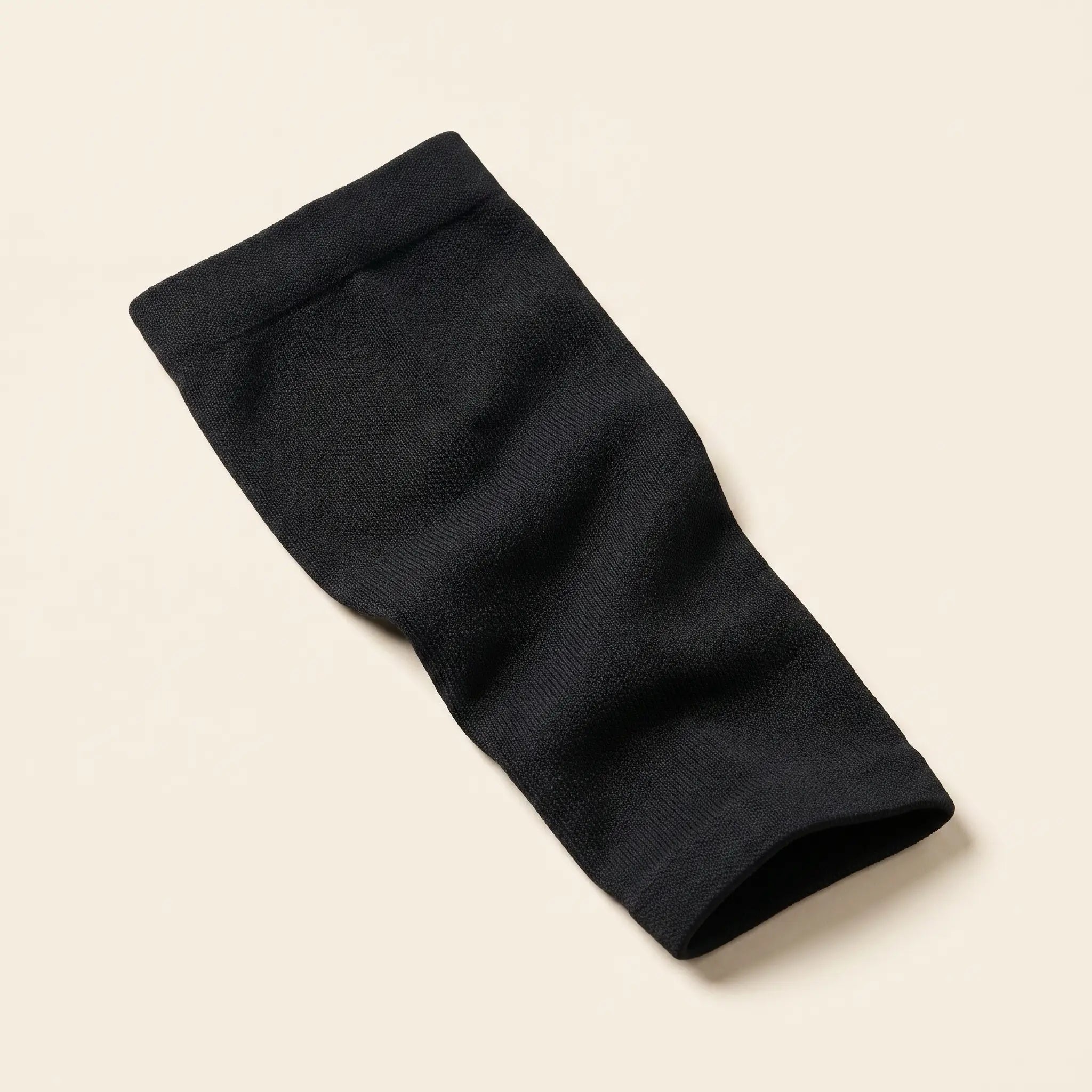 Manchon de compression mollet Flexnea noir tricoté, sur fond crème