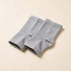 Paire de chevillères de compression Flexnea tricotées grises, sur fond crème