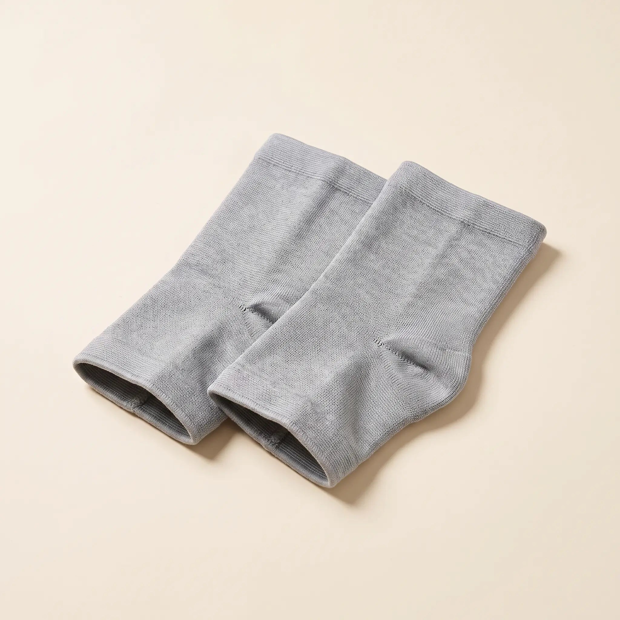 Paire de chevillères de compression Flexnea tricotées grises, sur fond crème